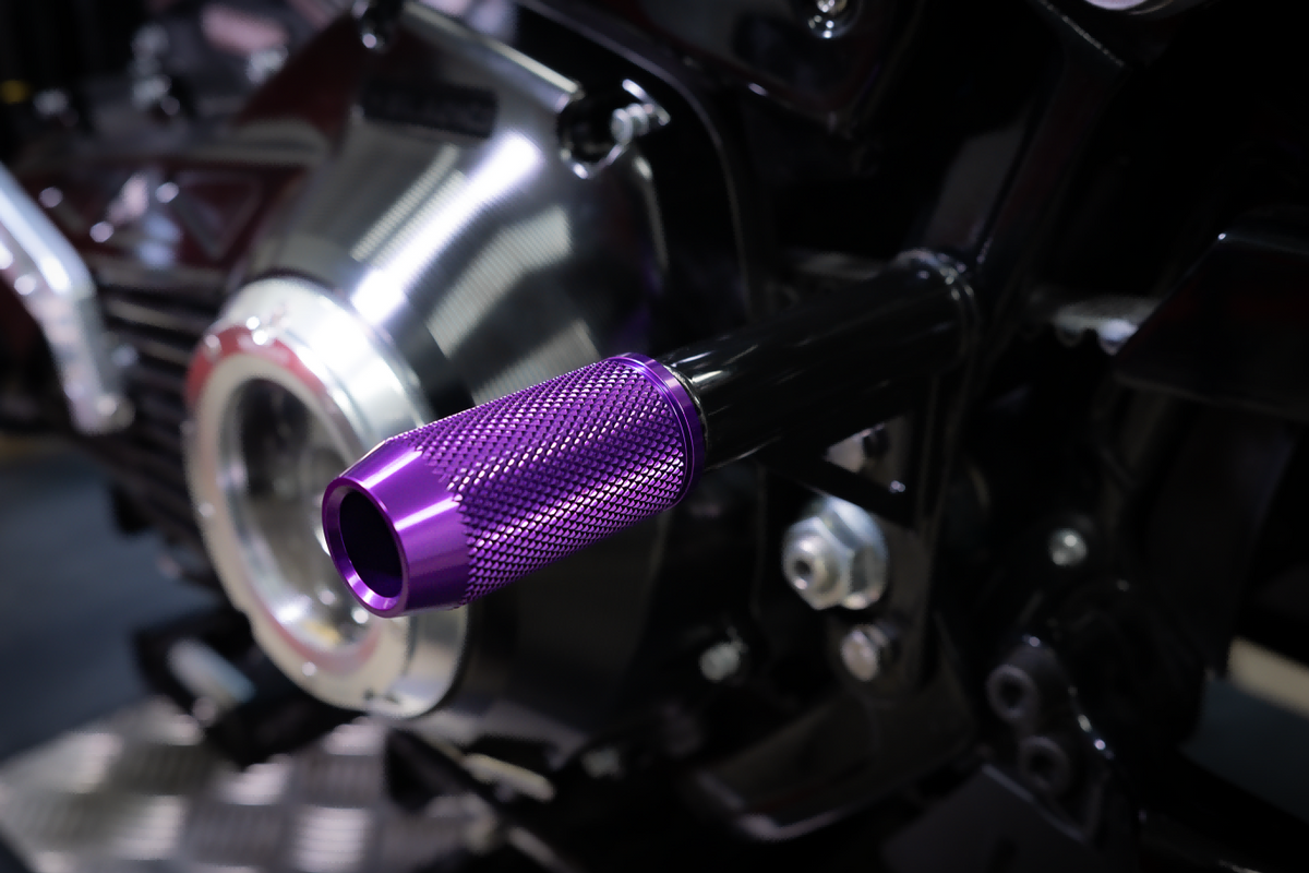 CNC crashbar sliders for Harley-Davidson, purple, installed on a Softail rear crashbar